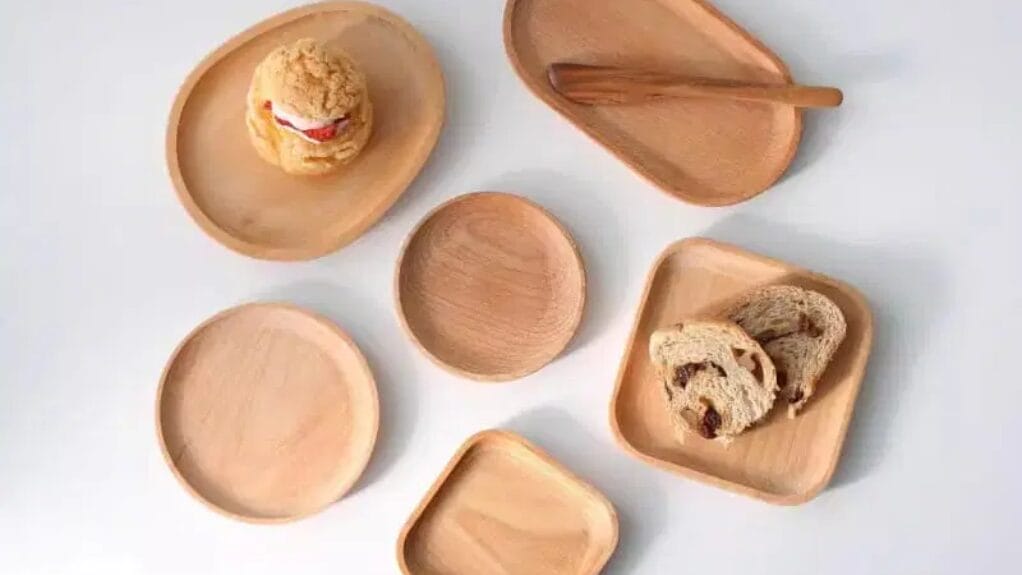 Assortiment de plateaux en bois de différentes formes avec pâtisseries et pain.