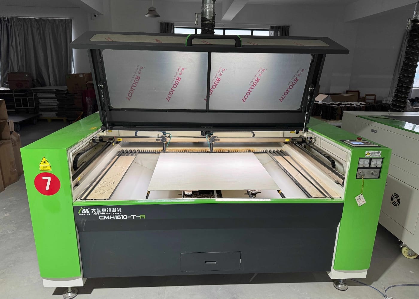 Green CMH1610-T-R laser cutting machine with a sheet of material inside.