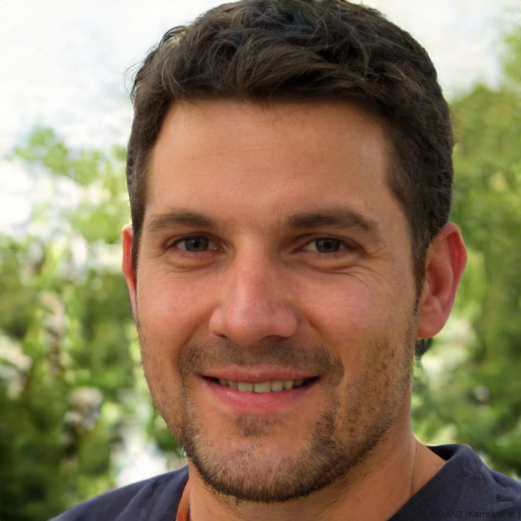 Friendly headshot of a man with short brown hair and a beard, smiling.