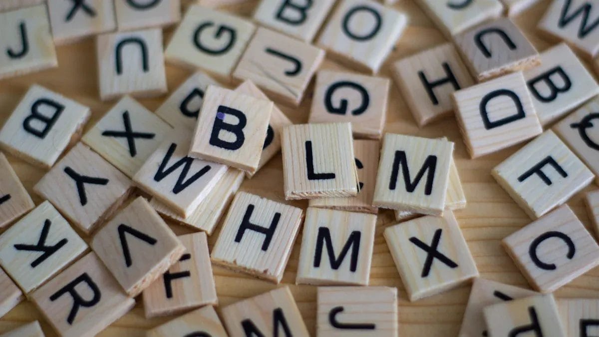 Carreaux de lettres en bois formant le mot « BLM » sur une table.