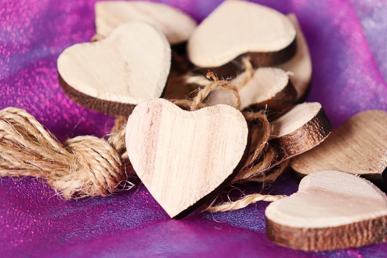 Formes en bois attachées avec de la ficelle sur du tissu violet.