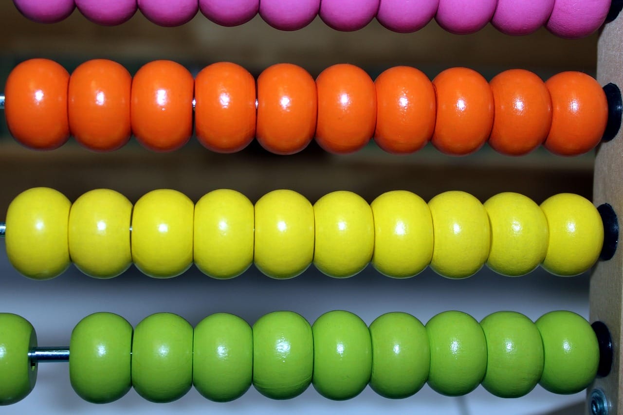 Boulier en bois coloré avec des rangées de perles roses, orange, jaunes et vertes.