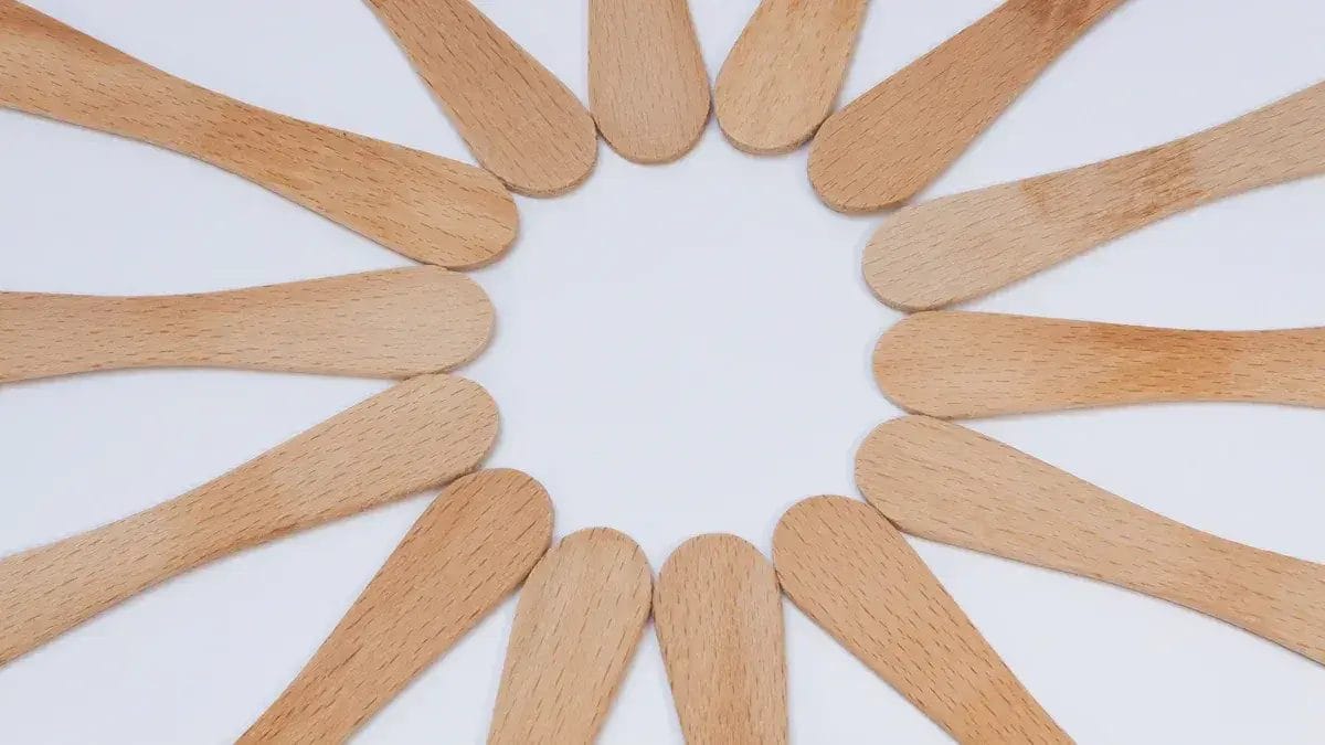 Boules de glace en bois disposées en cercle sur fond blanc.