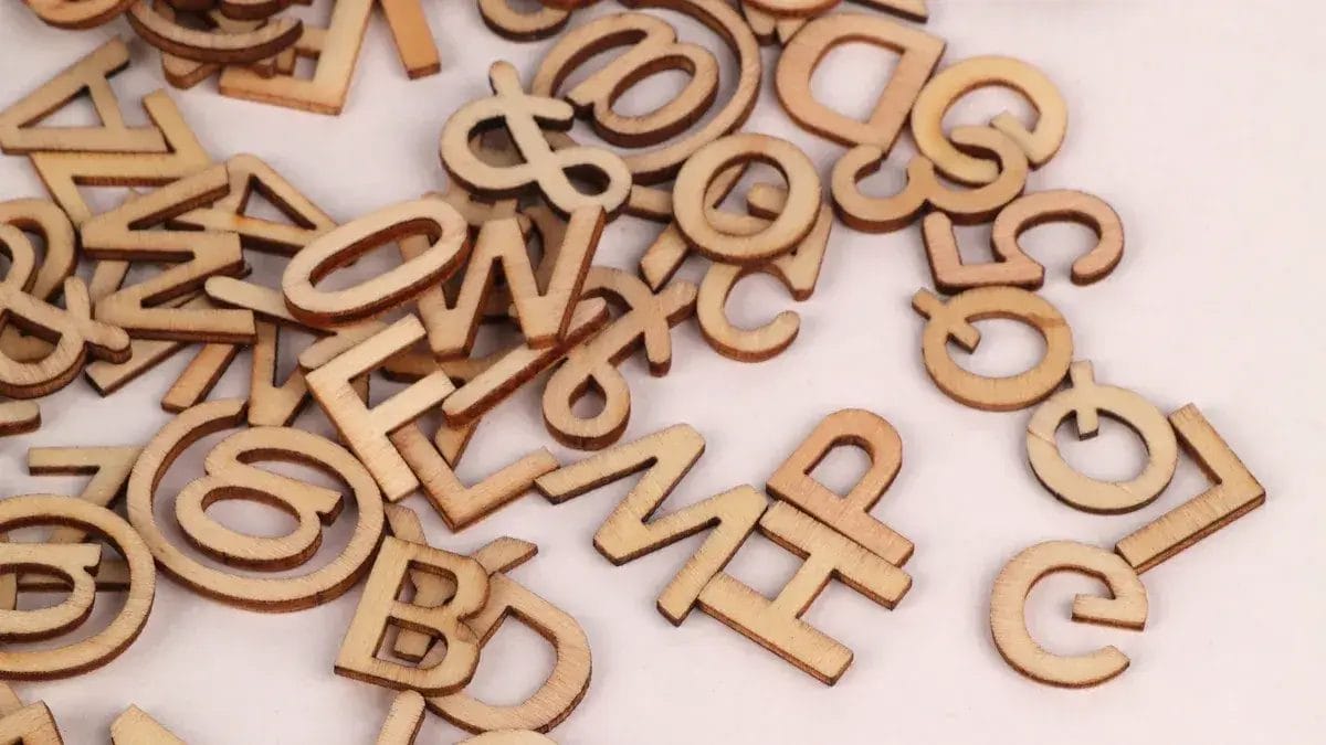 Chiffres et lettres en bois dispersés pour l'apprentissage des jeunes enfants. Idéal pour l'éducation préscolaire.