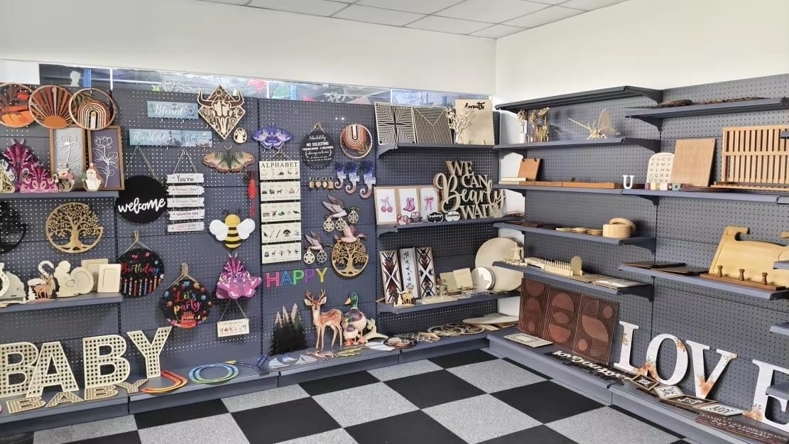 Étagères remplies de décorations murales en bois artisanales variées.