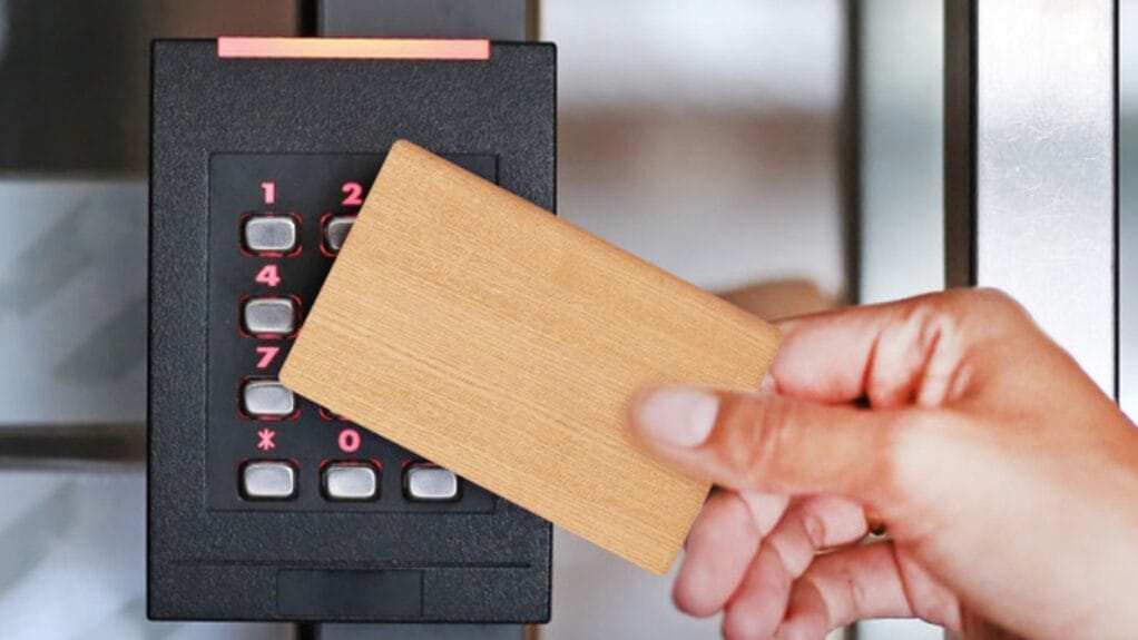 Main tenant passe sa carte sur un lecteur de badge pour ouvrir une porte