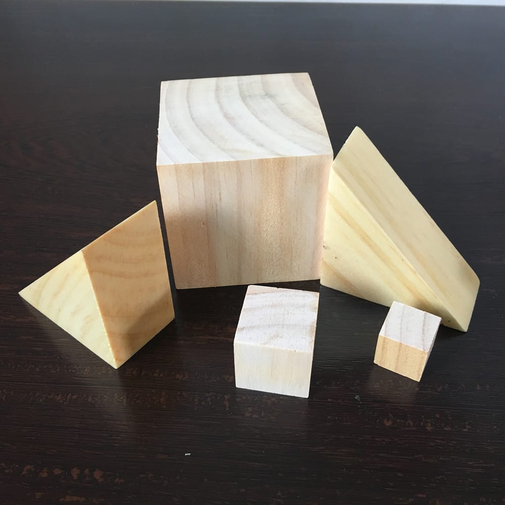 Blocs de bois variés : cube en pin, prismes triangulaires, pour modèles DIY.